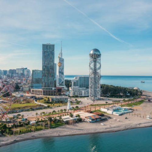 Drone photo of Batumi, Georgian resort at Black Sea, aerial panoramic view of downtown with ferris wheel and modern skyscrapers.