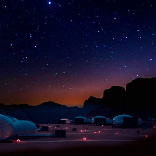 Milky Way and a lot of stars over the mountain at Wadi Rum desert.  Sky at night with wonderful landscape in summer, concept for space background and traveling.